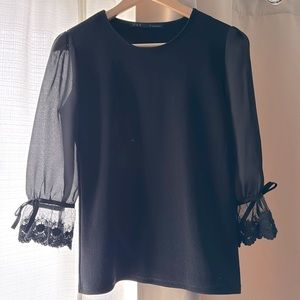 Women black top with see-through sleeves